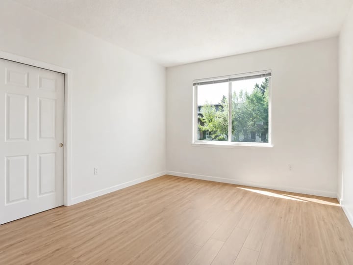 Empty bedroom with window light and plain walls
