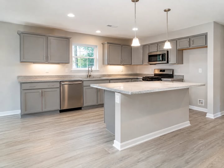 Empty kitchen shell with cabinets and window