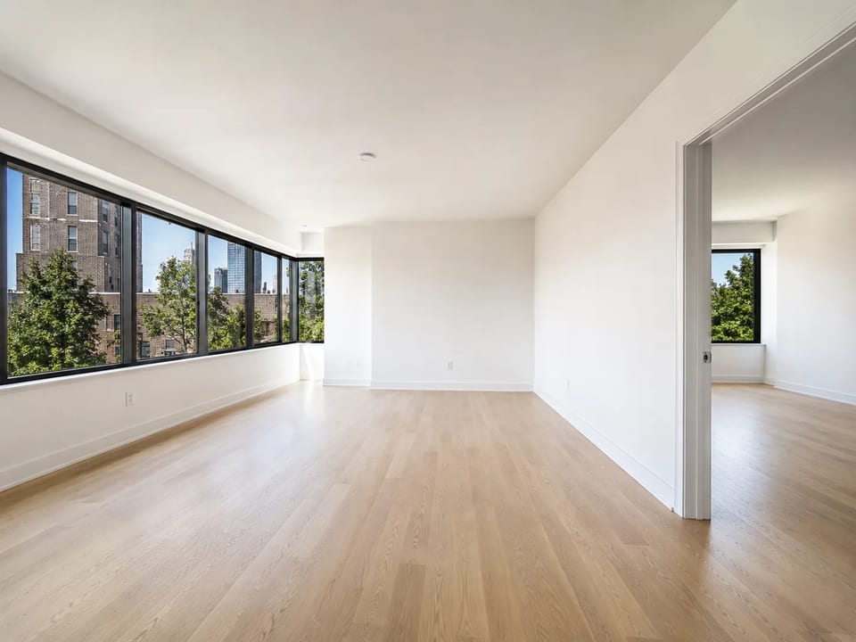 Empty living room with bare walls and windows
